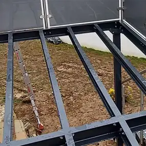 Stahlkonstruktion als Unterbau für eine Terrasse vor einem modernen Haus im Garten.